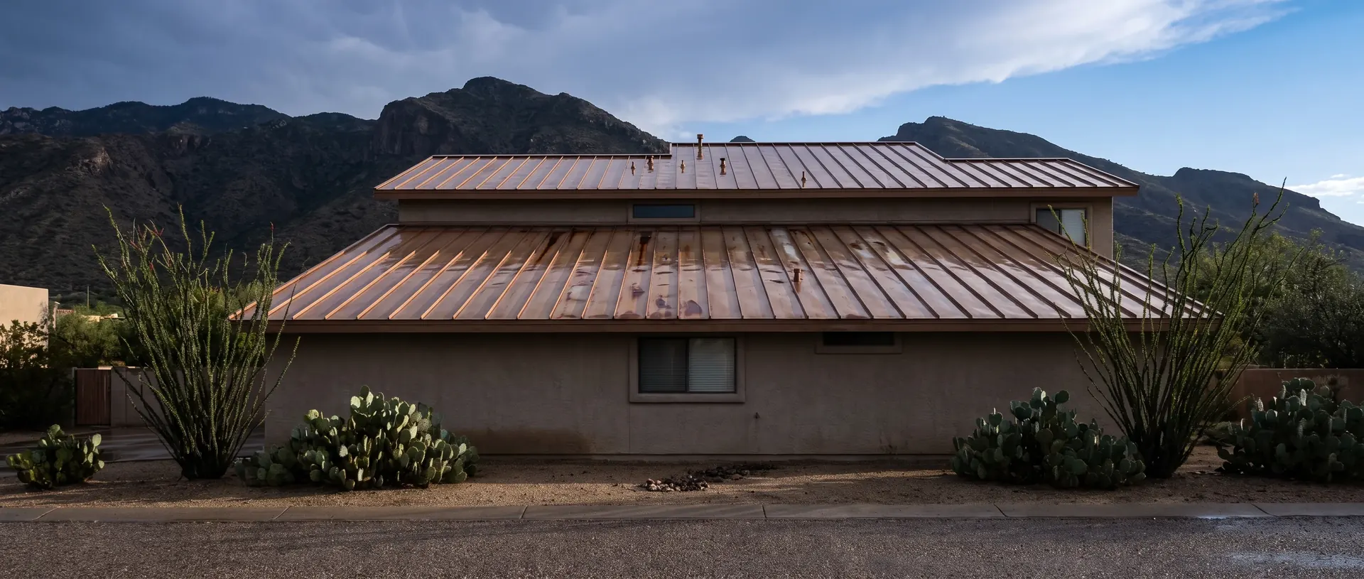 Oro Valley stucco house with a low profile standing seam metal roof below the Catalinas
