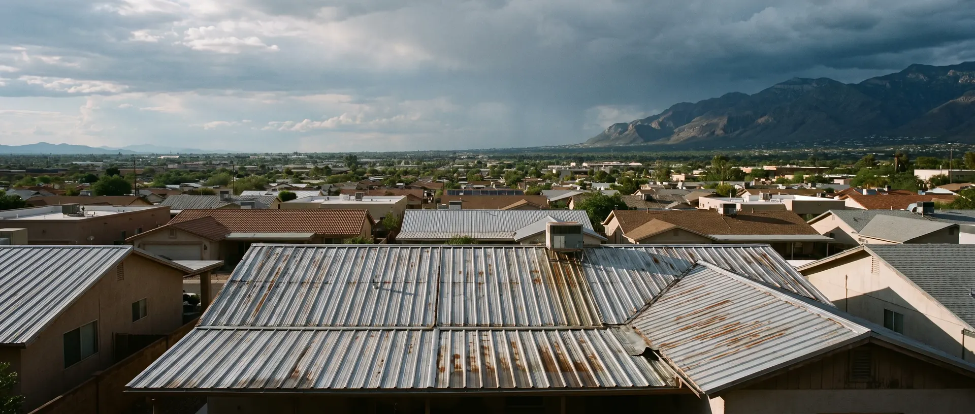 Metal roofs scattered across the Tucson valley with the Santa Catalina Mountains beyond