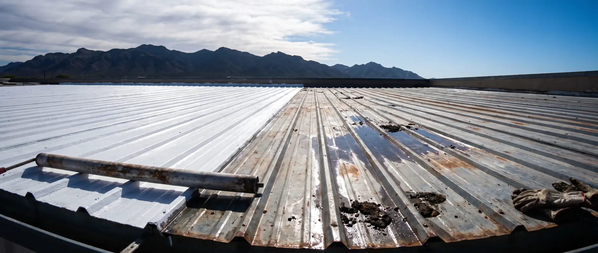 Tucson low slope metal roof half coated in reflective white and half still weathered grey